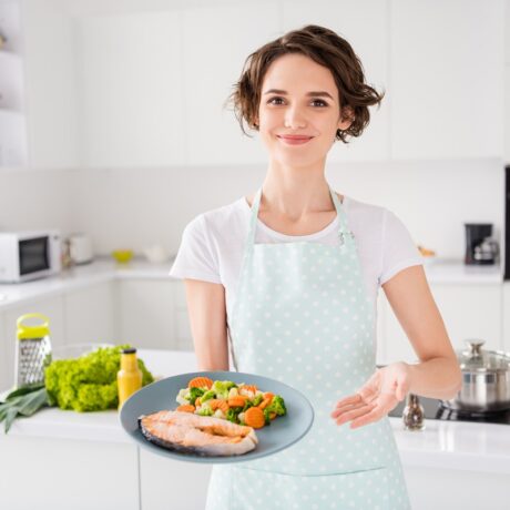 Femeie care servește somonul, unul dintre cele mai bune alimente pentru hipertensiune
